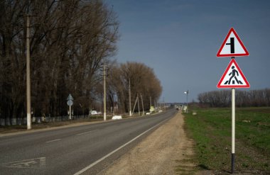 Yaya geçidi. Yol tabelası yaya geçidi. Yol sola gidiyor.