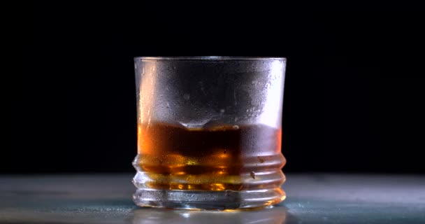 Super pomalý pohyb hození ledu do whisky. — Stock video