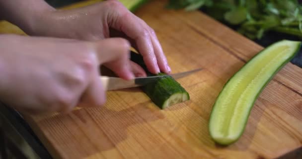 En tjej klipper gurkor på nära håll. sallad. Sommaren. hälsosam mat — Stockvideo