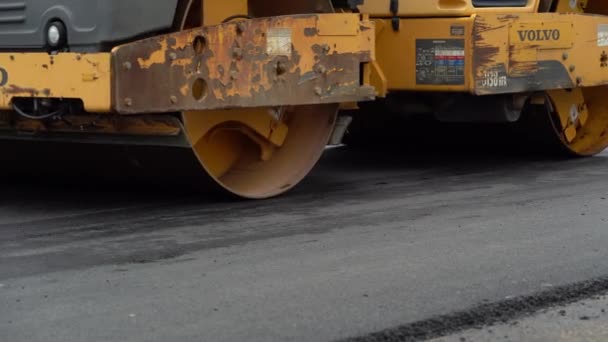 Bauarbeiter arbeiten auf der Straße. Arbeiter legten den heißen Asphalt auf. Reparatur Autobahn. Bau der neuen Straße mit Straßenreparatur. Straßenwalze. Schwere Maschinen. Nachtarbeit — Stockvideo