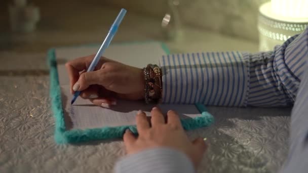 一个女人的手在笔记本里用钢笔写字。特写。4k镜头。生的 — 图库视频影像