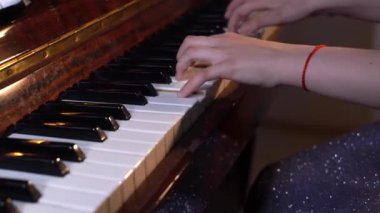 Çocuk elleri bir kuyruklu piyanoda hafif klasik müzik çalar. Profesyonel piyanist.