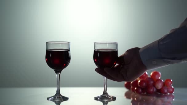 Vinho tinto. Uva. Mão de homem de close-up segurando o copo de vinho tinto. Mão com vinho tinto em copo de vinho cristalino. Vinho bar ou adega. degustação. — Vídeo de Stock