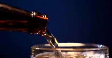 Su damlalarıyla dolu bir bardakta soğuk bira. Doldurulmuş bira. Bardağa bir şişe bira. Alkol konsepti. Barmen.