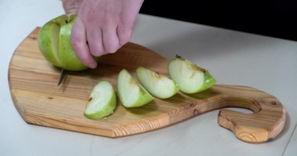 Klipper grönt äpple i skivor på träskiva sidovy — Stockvideo