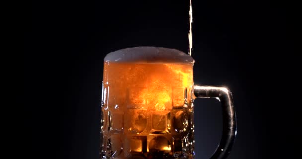 Pivo se nalévá do zahnutého skla. IPA na kohoutku. Studené světlé pivo ve sklenici s kapkami vody. Řemeslo Pivo tvořící vlny se blíží. Čerstvost a pěna. Pozadí baru. Mikrobivovarské pivo. — Stock video