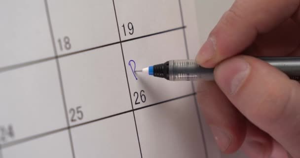 Mans χέρι γράφει την ημερομηνία της επίσκεψης μαμά στο ημερολόγιο. ένα σημαντικό γεγονός. Μην ξεχνάς. συνάντηση με φίλους. σήμανση στο ημερολόγιο. Σε ένα ημερολόγιο η υπενθύμιση για το τελευταίο παιχνίδι είναι γραμμένη. — Αρχείο Βίντεο