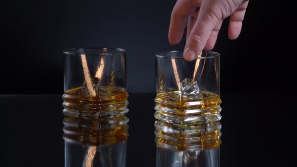 Mans hand takes the glass with a cold whiskey in slow motion — Stock Video