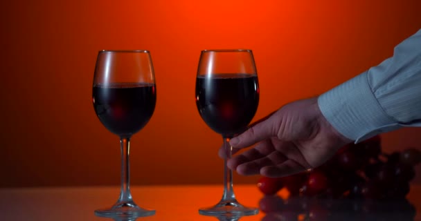 マンハンドは赤と白のワインとガラスを取ります。キーライトが低い。スローモーション — ストック動画