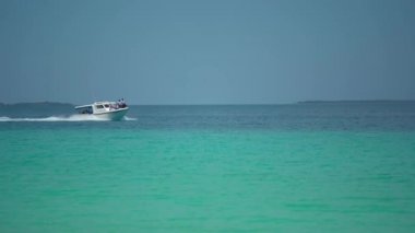 Maldivler 'de bir ada, açık deniz kıyısında üzerinde mercan kayalıklarıyla yüzen bir tekne, güzel bir turist uçağı. Tatil için cennet