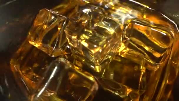 Barman stopt professionele kristallen ijsblokjes in een glas terwijl hij een alcoholische cocktail van whisky bereidt aan klanten in de bar of discotheek. Whisky of cognac drinken. Bovenaanzicht in slow motion — Stockvideo