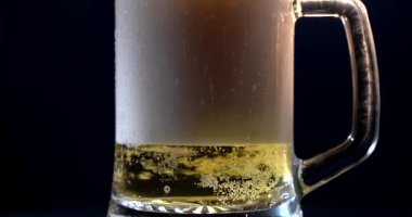 Bira açılı cama dökülüyor. IPA dinlemede. Su damlalı bir bardakta soğuk light bira. El yapımı bira dalgaları yaklaşıyor. Tazelik ve köpük. Bar geçmişi. Mikro bira fabrikası birası.