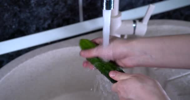 Ženská ruka umyje okurku ve vodě — Stock video