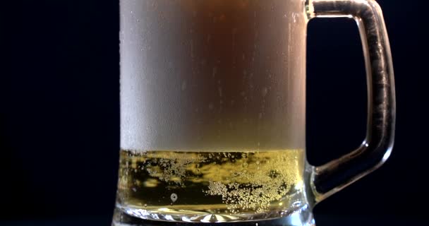 Beer is pouring into angled glass. IPA on tap. Cold Light Beer in a glass with water drops. Craft Beer forming waves close up. Freshness and froth. Bar background. Microbrewery craft beer. — Stock Video