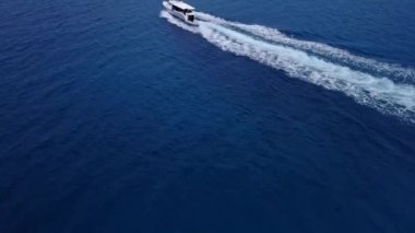 Beyaz Lüks Yat, temiz mavi deniz yüzeyinde seyrediyor. Okyanusta küçük dalgalarla Hız teknesinin üzerinden uçan uçak vuruldu. Hızlı sürat teknesi açık turkuaz sihirli okyanusta, yukarıdan. Karayipler. yakın