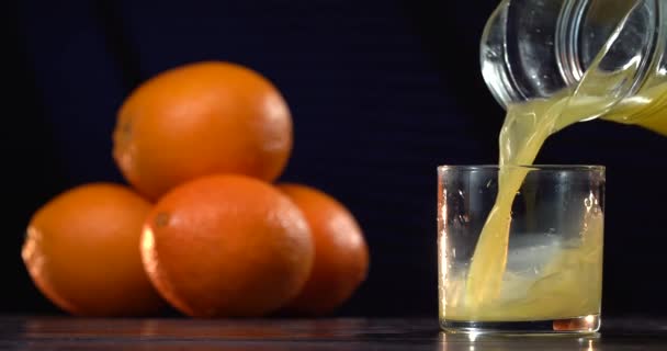 Стакан свежего апельсинового сока. Мужчина наливает свежий детоксикационный апельсиновый сок в стакан для освежения. Свежий детоксикации апельсиновый сок напиток может повысить витамин С. Здоровый образ жизни концепции. Летнее настроение. деревянный стол — стоковое видео