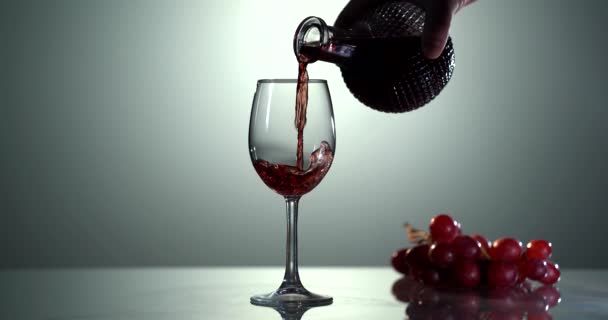 Primo piano di riempimento bicchiere di vino con vino rosso in super slow motion. Versare il vino rosso nel calice. Il vino rosso forma una bella onda in vetro — Video Stock