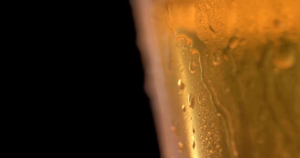 水滴のついたガラスの中の冷たいライトビール。クラフトビールを閉じます。360度回転。4K UHDビデオ3840x2160 — ストック動画