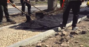 Şehir sokaklarında çalışıyorum. Hademe asfalt sokak kaldırımları döşedi.