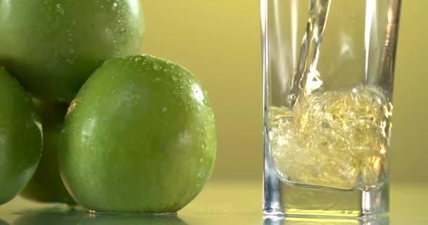 Pouring the apple juice into the glass. Fresh apples are on the table. — Stock Video