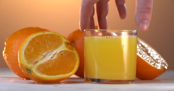 Mans mão leva o copo com suco de laranja da mesa — Vídeo de Stock