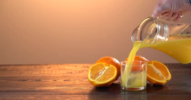 把橙汁倒入杯子里.新鲜果汁在桌子上.夏天的心情 — 图库视频影像