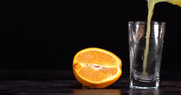 把橙汁倒入杯子里.黑暗的背景新鲜果汁在桌子上.夏天的心情 — 图库视频影像