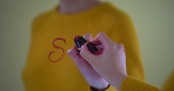 Hermosa mano femenina está escribiendo START. La palabra START escrito en lápiz labial rojo en la ventana, relación romántica, tarjeta de vídeo lindo día de San Valentín. La ventana está decorada con una guirnalda de — Vídeo de stock