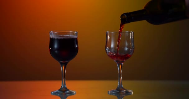 Червоне вино утворює красиву хвилю. Вино наливається в келих для вина на білому тлі. Крупним планом. Повільний рух заливання червоного вина з пляшки в чашку . — стокове відео