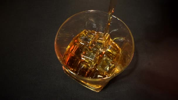 Super pomalý pohyb makro záběr nalévání whisky do skla s kostkami ledu — Stock video