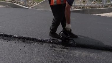 İnşaat işçileri yolda çalışıyor. İşçi takımı sıcak asfaltı yerleştirdi. Otoyol tamiri. Binanın Yeni Yolu, Yol Tamiri. Yol silindiri. Ağır makineler. Gece buharlı iş