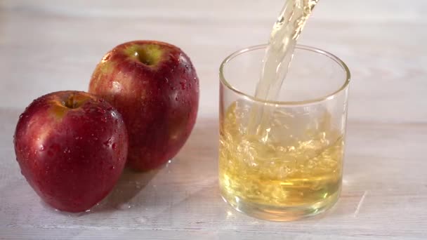 Super lenta tiro movimento de suco de maçã fresca sendo derramado em um copo — Vídeo de Stock