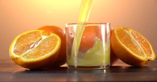 Tiro de verter el jugo de naranja en el vaso — Vídeos de Stock