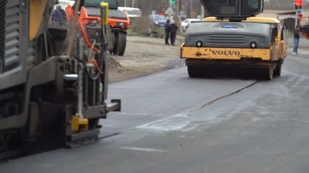 2021年5月20日：建設労働者が道路で働く。労働者のチームは、ホットアスファルトを置く。高速道路を修理しろ。道路の修復と新しい道路を構築します。ロードローラー。重機だ。夜の蒸気 — ストック動画