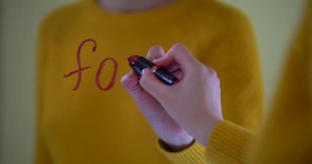 Mooie vrouwelijke hand schrijft liefdesboodschap. Het woord te koop geschreven in rode lippenstift op het venster. — Stockvideo