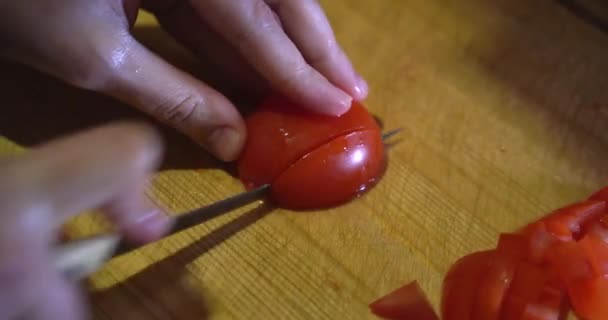 Frauenhände schneiden mit einem Küchenmesser frische Tomaten auf einem Holzschneidebrett. Gesunde Ernährung. Tomatenscheiben. Leckeres Essen zubereiten. Veganes Ernährungskonzept — Stockvideo