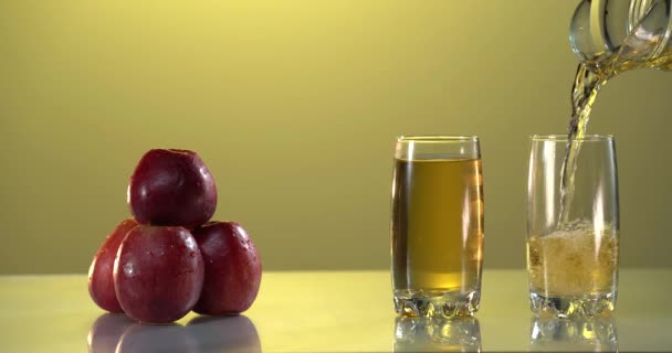 Membuat jus segar. Gerakan lambat rinci ditembak menuangkan jus apel lezat ke dalam gelas transparan terhadap latar belakang putih. Tutup. Makanan sehat, vitamin, buah-buahan. Video 4K. Nutrisi — Stok Video
