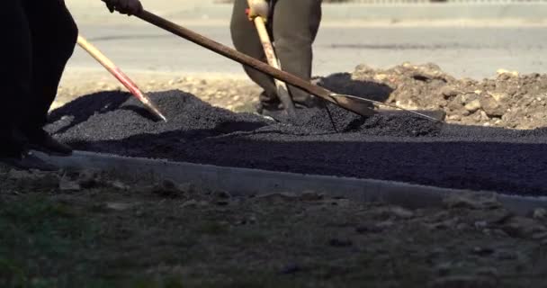 Beim Straßenbau wird neuer Asphalt verlegt. Fertiger oder Pflastermaschine verlegen Bitumen. Rollen ebnen und kompakter neuer Asphalt. Fahrbahnsanierung. Bau einer neuen Straße — Stockvideo