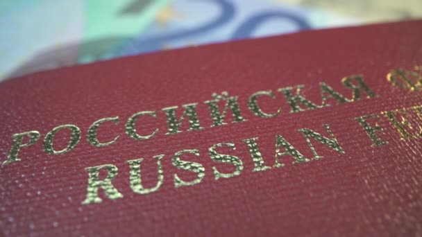 Fédération de Russie passeport de premier plan du citoyen. Couverture rouge. Macro photo de l'inscription. Lumière dorée sur le titre. Billet de 20 euros sur le fond. — Video