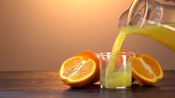 Menuang jus jeruk dari botol kaca ke kaca. Tutup gelas jus jeruk segar. Menyiapkan sarapan sehat dari bahan alami. Jus buah buatan sendiri di atas meja. Minuman vitamin organik — Stok Video