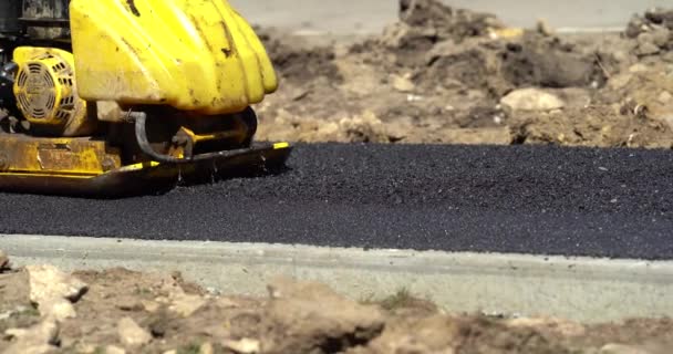 Nova York, EUA - 15 de julho de 2020: Dois trabalhadores rodoviários despejando o asfalto. Um caminhão de carga despeja mistura de concreto asfáltico em um funil de paver para reparo de estradas — Vídeo de Stock