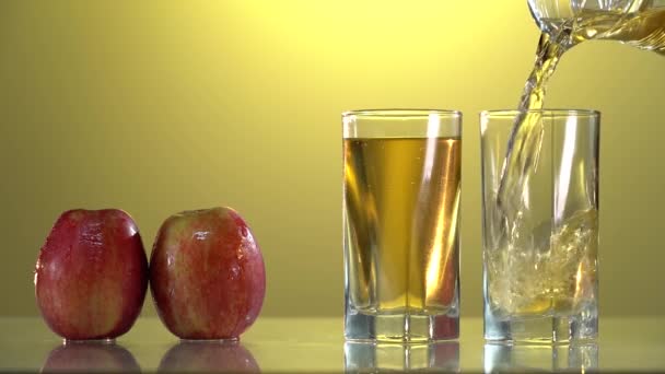 Розміщення соку з Apple виливається у скло на білому столі. Цитрусовий сік сповільнює рух. — стокове відео
