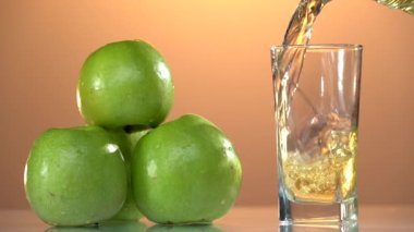 Bardağa yakın çekim üzerine elma suyu dök. Taze meyve suyu yapıyorum. Beyaz arka plana karşı şeffaf bir bardağa lezzetli elma suyu dökerken yavaş çekim. Kapatın. Sağlıklı
