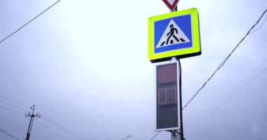 Trafik ışıkları, kırmızı ışıklar yeşile döner. Kavşak. Yaya geçidi tabelası. Bulutlu bir gün. Yol güvenliği kavramı. Geri sayım