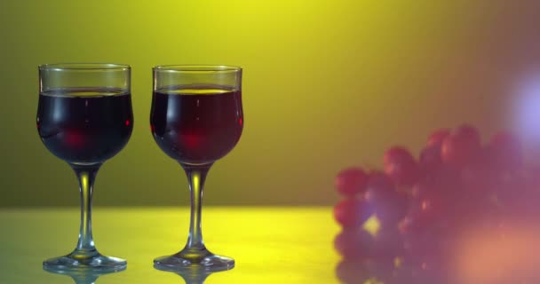 'νθρωποι που κρατάνε ποτήρι κρασί, γενέθλια. Φίλοι πίνουν λευκό κρασί, κάνουν πρόποση. Κλίνκ. Τρία ποτήρια στο τραπέζι με κίτρινο φόντο. σταφύλια κοντά στην κόκκινη άμπελο — Αρχείο Βίντεο