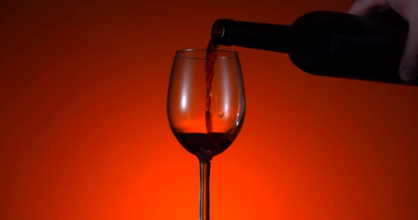 Vino rosso forma bella onda. Vino versando in bicchiere di vino su sfondo nero. Un primo piano. Colore sfondo. Bottiglia scura di alcol. Concetto pubblicitario — Video Stock