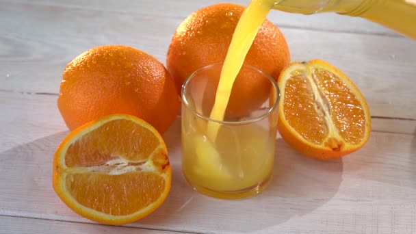 신선 한 오렌지 주스를 유리에 넣는 고속 슬로우 모션 샷 — 비디오
