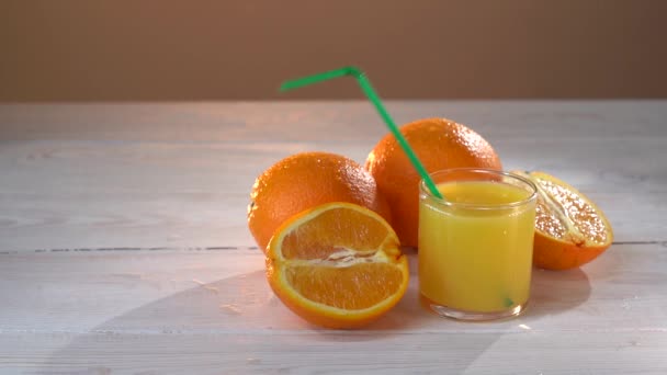 La paja cae en el vaso con jugo de naranja — Vídeos de Stock