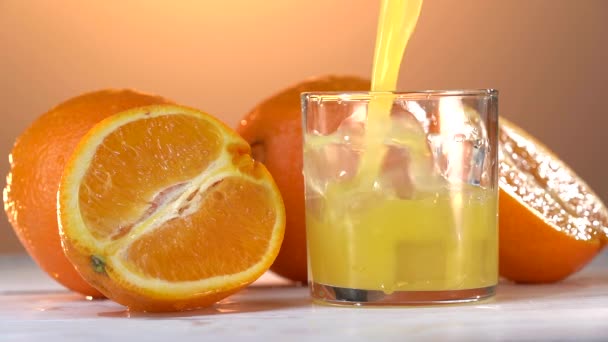 Orange juice is pouring into the glass in Slow Motion Shot — Stock Video