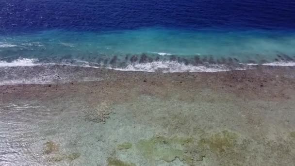 Aerial view, looking down at the shore of a tropical island. Waves wash shore of ocean of the Caribbean Sea. Clear water. Lagoon — Stock Video